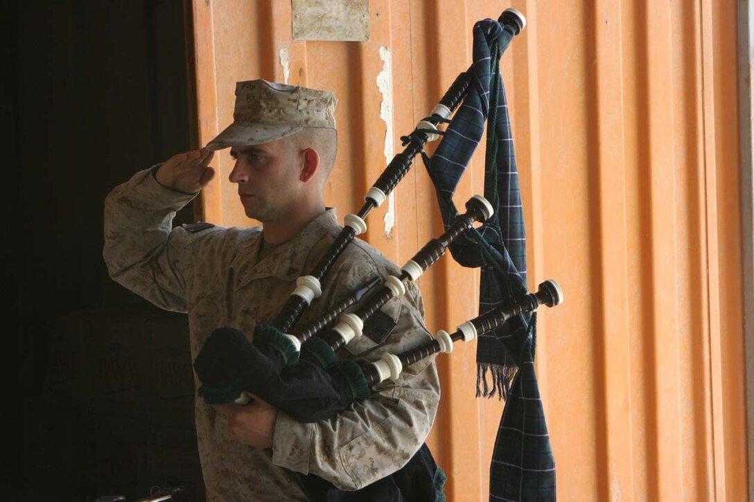 CAMP FALLUJAH, IRAQ -- Lance Cpl. Matthew Bucceri salutes during the playing of TAPS during a memorial service for fallen Marine, Lance Cpl. John T. Schmidt.  Bucceri played Amazing Grace and the Marine Corps Hymn on his bagpipes during the cermony where Marines from India Company, 3rd Battalion, 8th Marine Regiment.  Official U.S. Marine Corps photo by Lance Cpl. Athanasios L. Genos