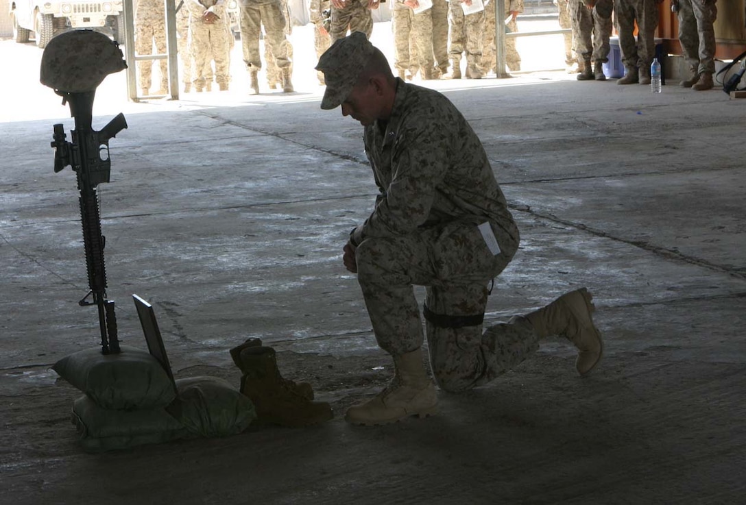 CAMP FALLUJAH, IRAQ -- Third Battalion, 8th Marine Regiment Battalion Commander, Lt. Col. Stephen M. Neary kneels down in front of fallen Marine, Lance Cpl. John T. Schmidt's rifle, boots, helmet and dog tags.  Schmidt succumbed to his wounds sustained in a rocket propelled grenade attack January 30 at Observation Post 2 in the city of Al Karmah.  Official U.S. Marine Corps photo by Lance Cpl. Athanasios L. Genos