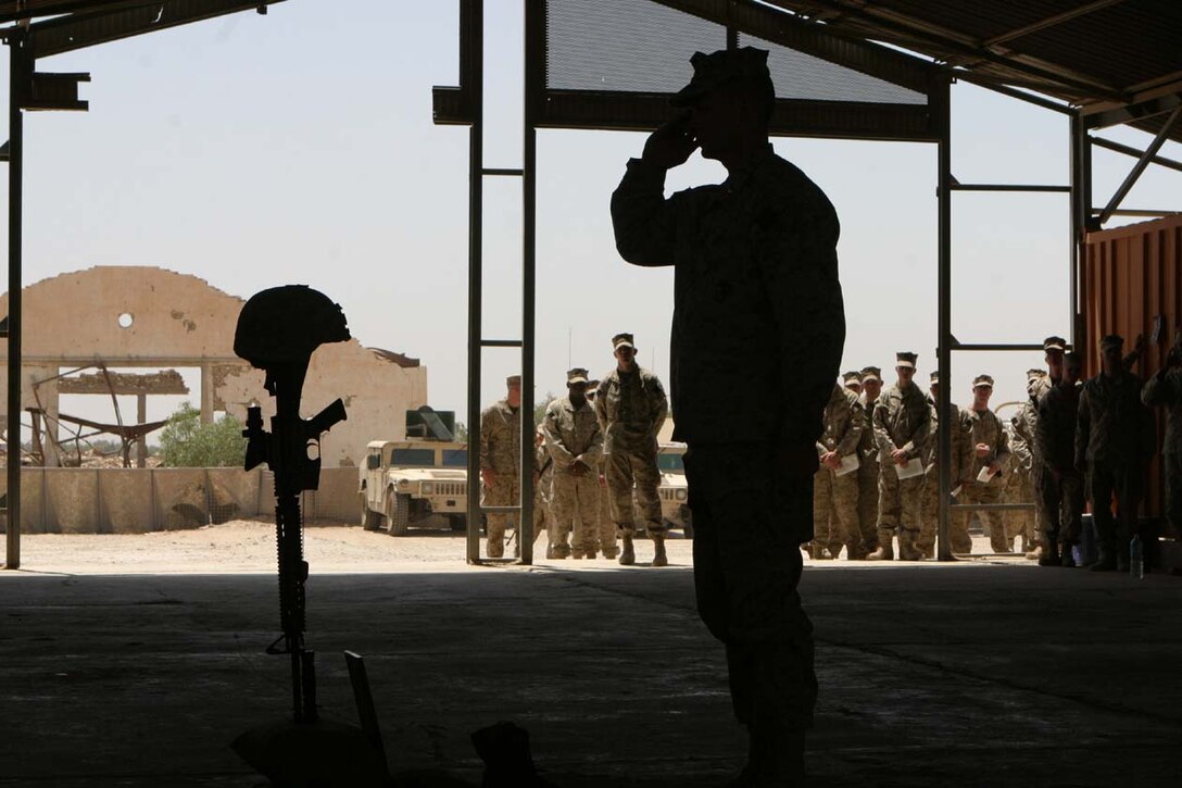 CAMP FALLUJAH, IRAQ -- Third Battalion, 8th Marine Regiment Battalion Commander, Lt. Col. Stephen M. Neary gives his final salute to Lance Cpl. John T. Schmidt during a memorial service honoring Schmidt's life as a Marine.  He succumbed to his wounds received from a rocket propelled grenade attack January 30 at Observation Post 2.  Official U.S. Marine Corps photo by Lance Cpl. Athanasios L. Genos