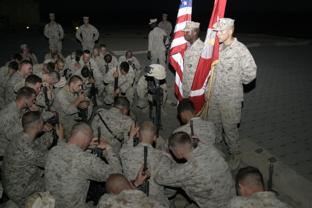 CAMP AL QA'IM, Iraq (June 21, 2005)- Marines with Company K, 3rd Battalion, 2nd Marine Regiment, Regimental Combat Team-2 gather around a memorial monument for Lance Cpl. Adam J. Crumpler, an infantryman with the company who was killed in action during Operation Spear, an operation conducted to destroy insurgent strongholds in the city of Karabilah, Iraq. Official U.S. Marine Corps photo by Lance Cpl. Lucian Friel (RELEASED)