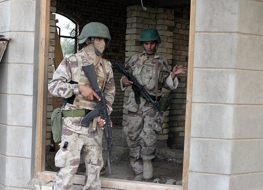 SAQLAWIYAH, Iraq - Iraqi soldiers exit a home after searching it for weapons during Operation Hard Knock here July 21.  Iraqi Security Forces worked alongside Company A, 1st Battalion, 6th Marine Regiment personnel to sweep through northern Saqlawiyah's Al Zakarit district to look for weapons and insurgent activity, as well as gather census information on the populace.