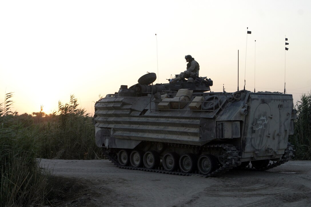 SAQLAWIYAH, Iraq - An amphibious assault vehicle provides security along a dirt road here July 21 during Operation Hard Knock.  AAVs assisted Company A, 1st Battalion, 6th Marine Regiment personnel and Iraqi Security Forces in sweeping through northern Saqlawiyah's Al Zakarit district to look for weapons and insurgent activity, as well as gather census information on the populace.