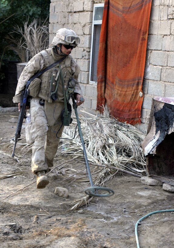 SAQLAWIYAH, Iraq - A combat engineer with 2nd Platoon, Company A, 2nd Combat Engineer Battalion uses his metal detector to search for hidden weapons here July 21 during Operation Hard Knock.  Combat engineers assisted Company A, 1st Battalion, 6th Marine Regiment personnel and Iraqi Security Forces in sweeping through northern Saqlawiyah's Al Zakarit district to look for weapons and insurgent activity, as well as gather census information on the populace.