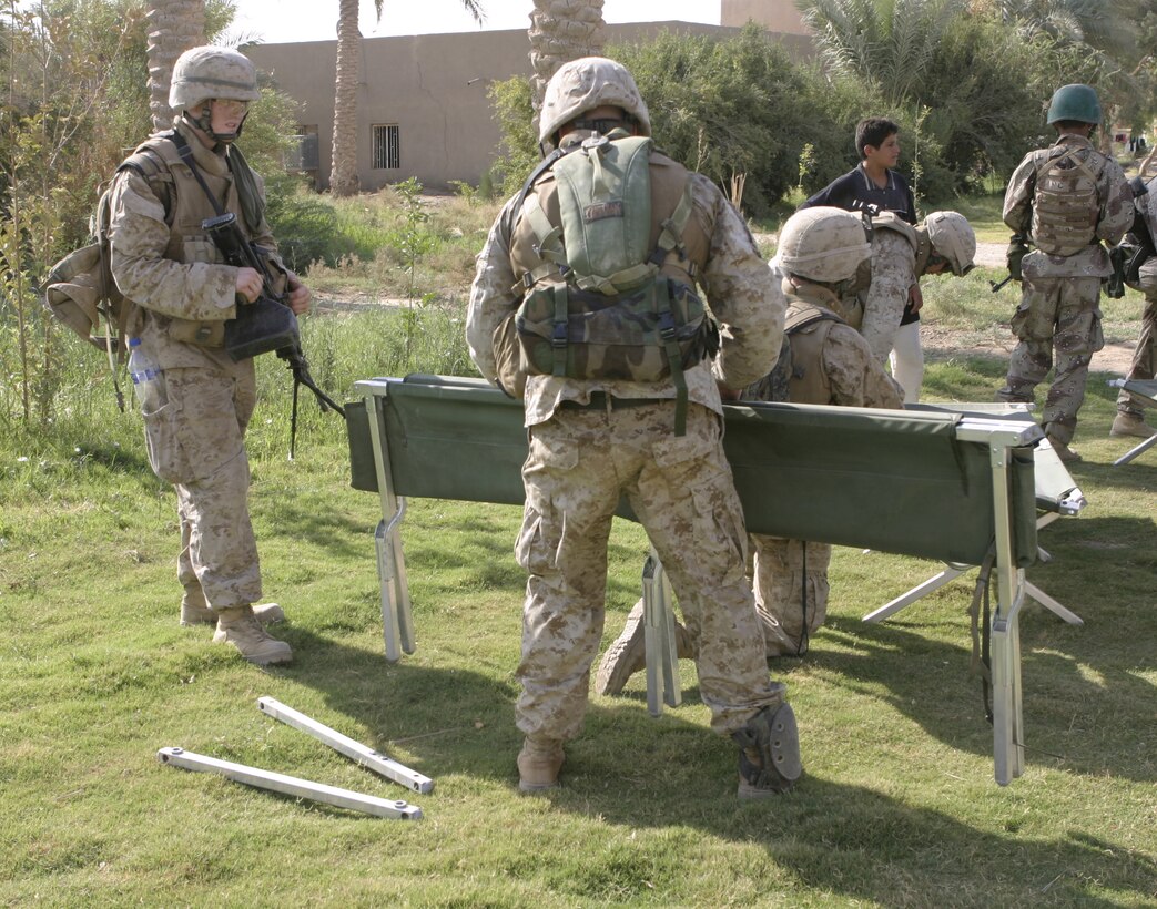 SAQLAWIYAH, Iraq - Marines with Company A, 1st Battalion, 6th Marine Regiment break down several military-style cots found inside a residency here July 21 during Operation Hard Knock.  Company A personnel worked alongside Iraqi Security Forces to sweep through northern Saqlawiyah's Al Zakarit district to look for weapons and insurgent activity, as well as gather census information on the populace.