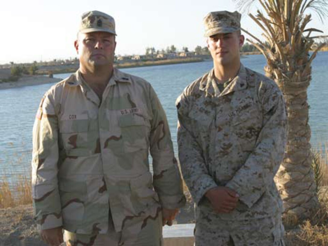 Army 1st Sgt. William K. Cox (left), company first sergeant for Bravo Battery, 1st Battalion, 623rd Field Artillery, and his son, Cpl. Winston A. Cox (right), a gunner with Weapons Company, 2nd Battalion, 6th Marines had the rare opportunity to celebrate Thanksgiving together while deployed to Iraq. Both father and son are deployed to Iraq in support of Operation Iraqi Freedom.