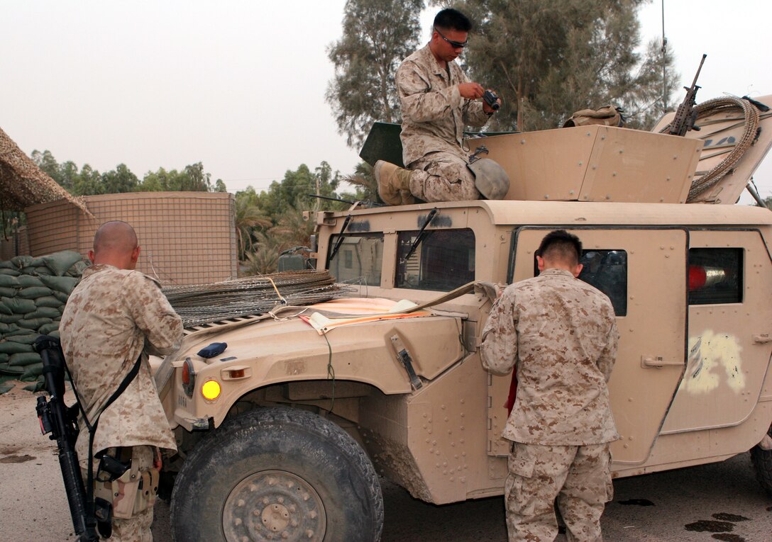 Marines from 3rd Reconnaissance Battalion, 2nd Marine Division, prepare for an operation June 21 in front of their headquarters at Camp Fallujah. After more than 30 years without deploying as a battalion, ?The Men of the Forward Shadow? landed in Iraq mid-March to conduct combat operations in Al Anbar province.