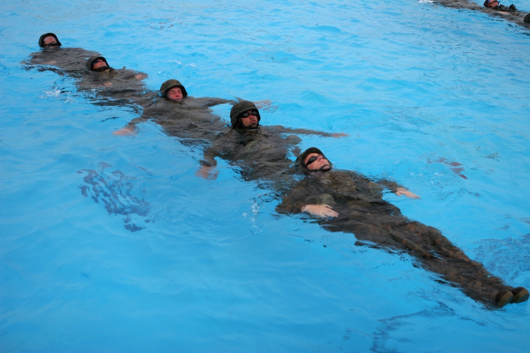 050721-M-8909M-004 CAMP SCHWAB, OKINAWA, Japan - Marine Combat Instructor Water Survival Course students perform a dragon boat exercise during a water aerobics session at the Camp Schwab Aquatic Center July 19. Water aerobics sessions are part of the conditioning and strengthening portion of the course and consisted of swimming different strokes above water and underwater, strength-training activities in the water and exercises along the edges of the pool. (Official U.S. Marine Corps photo by Lance Cpl. Erin F. McKnight)(released)