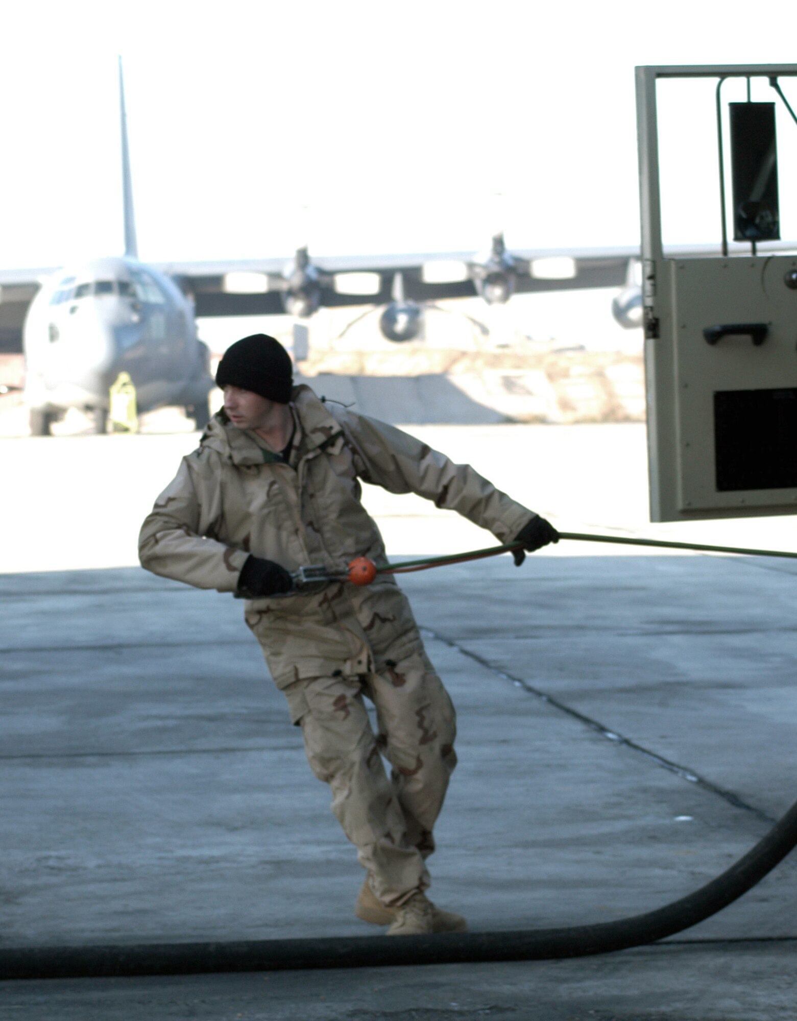 KARSHI-KHANABAD AIR BASE, Uzbekistan -- Airman 1st Class Derrick Dillon works at his fuel truck during the fueling of a C-17 Globemaster III here Jan. 19.  He is a fuels distribution journeyman deployed from Charleston Air Force Base, S.C., to the 416th Expeditionary Mission Support Squadron fuels management flight here.  (U.S. Air Force photo by Tech. Sgt. Scott T. Sturkol)
