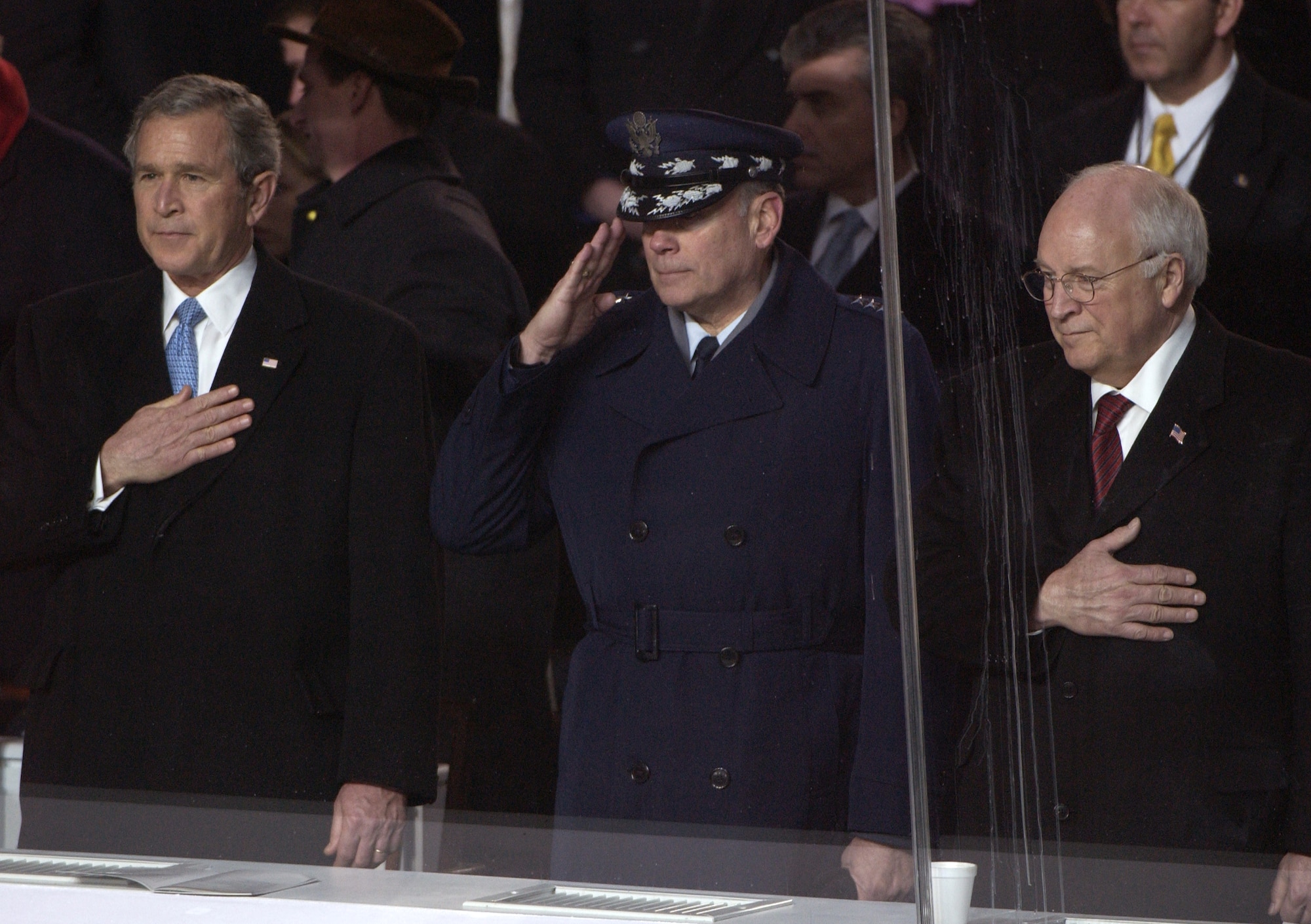 WASHINGTON -- President George W. Bush (from left), Air Force Chief of Staff Gen. John P. Jumper and Vice President Dick Cheney salute as the American flag passes during the 2005 Presidential Inaugural Parade here Jan. 20, 2005.  (U.S. Air Force photo by Tech. Sgt. Tracy DeMarco)
