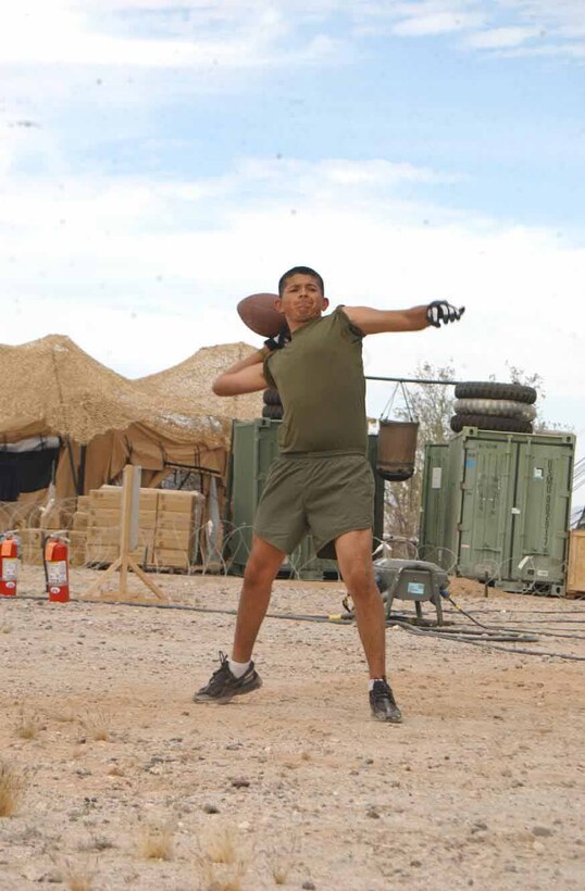 Lance Cpl. Jose Gomez-Aguilar, 1st Maintenance Battalion, 1st Force Service Support Group, Marine Corps Base Camp Pendleton, Calif., basic hygiene operator, tosses a football around during his free time at Site 50 during the Weapons and Tactics Instructor course April 6.