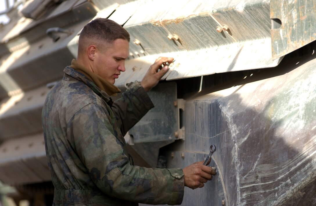LCpl, Mathew Blissitt, with Echo Company, 3rd Amphibious Assault Battalion (3rd AAB), 11 MEU (SOC) works to remove nuts and bolts as part of the cleaning procedure on an AAVP7A1 on FOB Duke, Iraq 21 January 21, 2005.  Marines of 3rd AAB will spend the next few days' completing a pre wash down process.     Official USMC photo by: GySgt Robert K. Blankenship