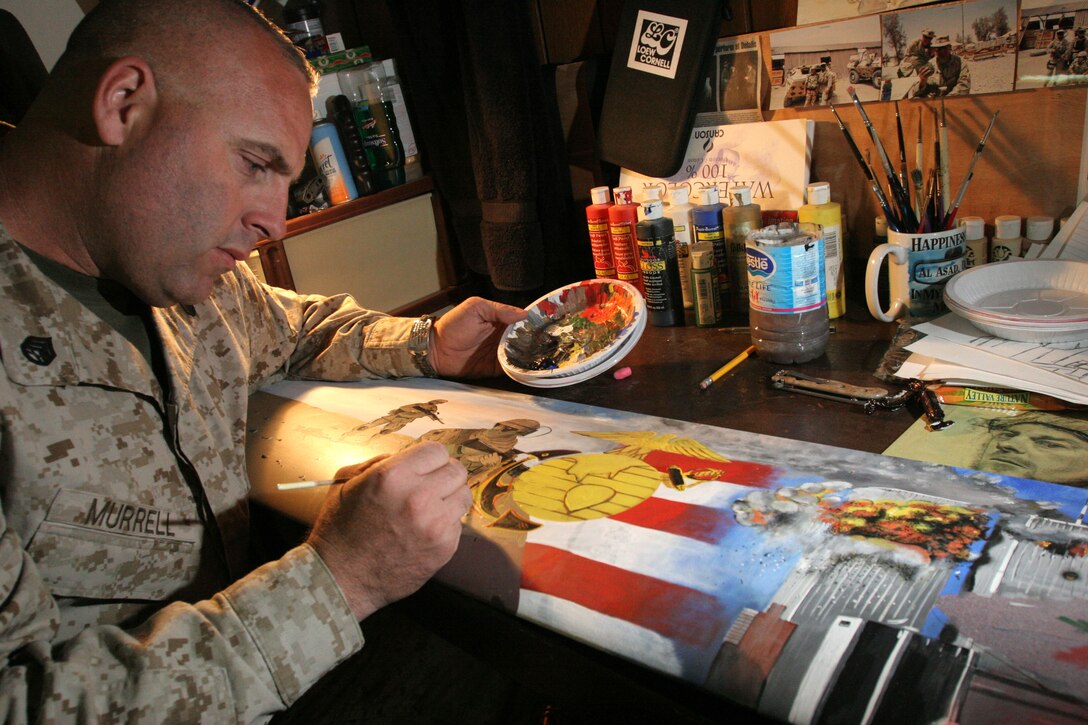 Staff Sgt. Michael Murrell, the 500 division quality assurance representative at Marine Aviation Logistics Squadron 26 (Reinforced), paints on a trashed helicopter blade at Al Asad, Iraq, Oct. 22. He said the plane flying into one of the Twin Towers stands as a powerful reminder of why we are here and who we are fighting. He stressed he does not want to sugarcoat his art and hopes it will remind people what happened that day years down the road.