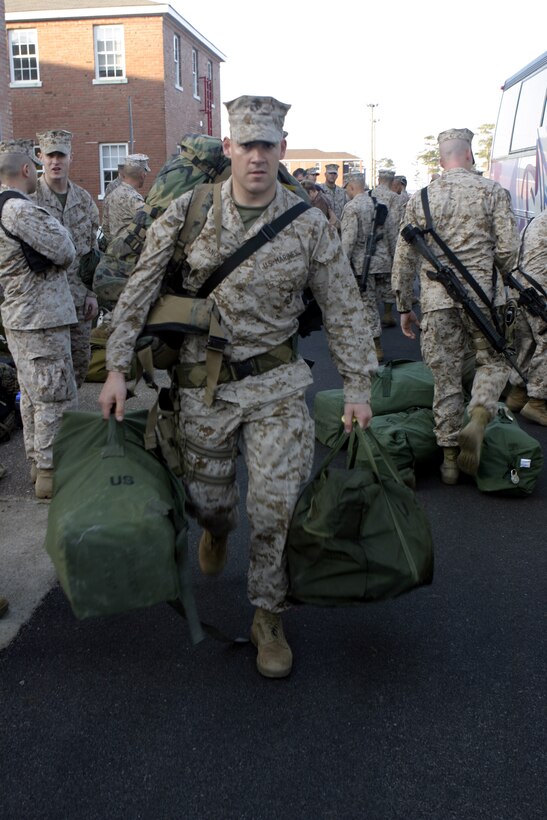 MARINE CORPS BASE CAMP LEJEUNE, N.C. - Capt. Robert M. Hancock, Company B, 1st Battalion, 6th Marine Regiment commanding officer, rushes to a nearby bus carrying his baggage and weapons.  Hancock was one of approximately 50 Marines and sailors to leave here for Iraq as part of 1st Battalion, 6th Marine Regiment's advance party to help pave the way for the arrival of the main body in March.