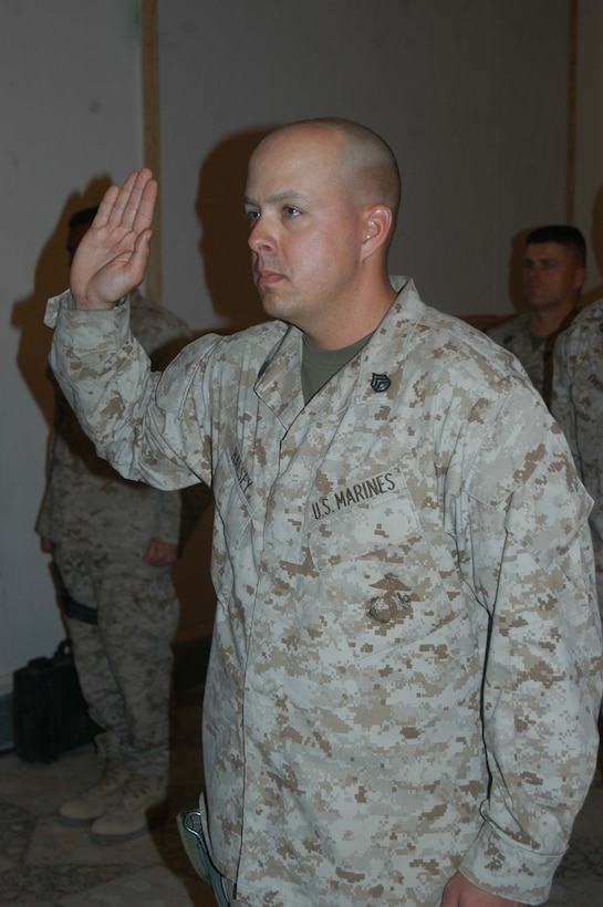 CAMP HURRICANE POINT, Ar Ramadi, Iraq (April 22, 2005) - Staff Sgt. Keith L. Halsey, logistics chief, Headquarters and Service Company, 1st Battalion, 5th Marine Regiment, holds up his right hand and takes his oath of reenlistment during a ceremony here. Fellow leathernecks with the infantry battalion attended to honor the 30-year-old Syracuse, N.Y., native on his special day. Halsey has been proudly wearing the Eagle, Globe and Anchor for the past decade and plans on serving for another 10 years. Photo by Cpl. Tom Sloan