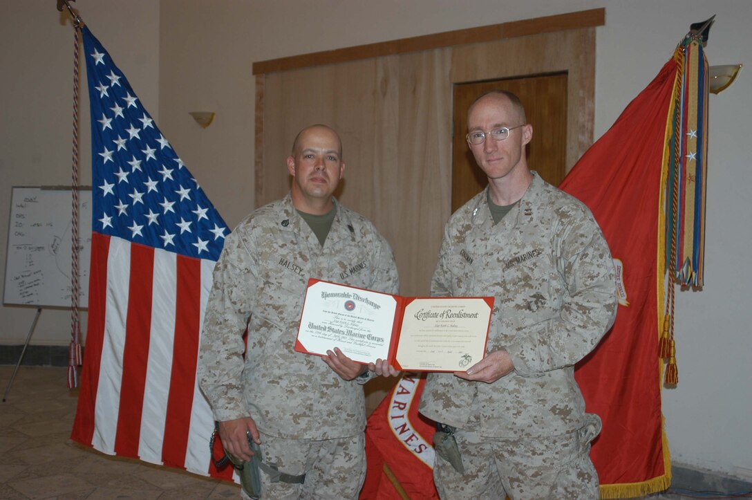 CAMP HURRICANE POINT, Ar Ramadi, Iraq (April 22, 2005) - After reenlisting during a ceremony here, Staff Sgt. Keith L. Halsey, logistics chief, Headquarters and Service Company, 1st Battalion, 5th Marine Regiment, holds his certificate of reenlistment with Capt. Daniel H. Coleman, H&S Company's logistics officer. The 30-year-old Syracuse, N.Y., native has been proudly wearing the Eagle, Globe and Anchor for the past decade and plans on serving for another 10 years. Photo by Cpl. Tom Sloan