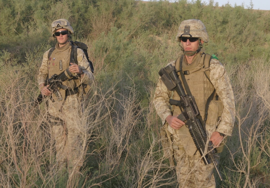SAQLAWIYAH, Iraq - As the sun rises, two Marines with 3rd Squad, 2nd Platoon, Company A, 1st Battalion, 6th Marine Regiment observe their surroundings in a field outside Saqlawiyah May 22.  Company A personnel worked alongside Iraqi soldiers and combat engineers to sweep through numerous farm fields outside Saqlawiyah, looking for hidden weapons caches and insurgent activity.