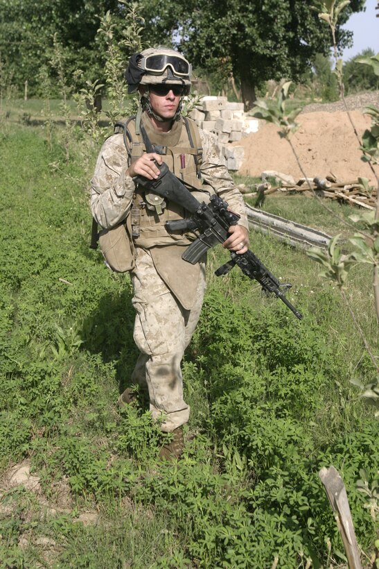 SAQLAWIYAH, Iraq - Lance Cpl. Marc G. Allison, a rifleman with 3rd Squad, 2nd Platoon, Company A, 1st Battalion, 6th Marine Regiment, patrols through a field outside Saqlawiyah May 22.  Company A personnel worked alongside Iraqi soldiers and combat engineers to sweep through numerous farm fields outside Saqlawiyah, looking for hidden weapons caches and insurgent activity.