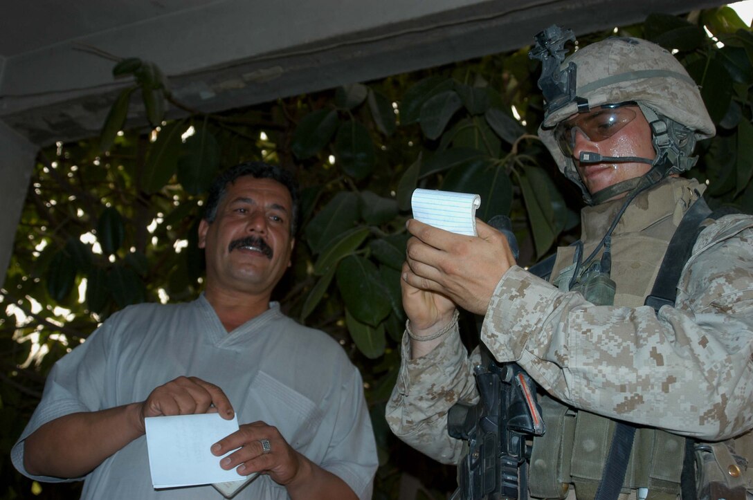 AR RAMADI Iraq (June 20, 2005) - Corporal Donald W. Ball, a team leader and machine gunner with 3rd Squad, 4th Platoon, Company B, 1st Battalion, 5th Marine Regiment, records an Iraqi man's name and information during a patrol through the city here June 20. It was the 22-year-old Salt Lake City natives last combat mission. Ball is a three-time veteran of Operation Iraqi Freedom. He leaves Iraq in July and the Marines with an honorable discharge in September. He plans on attending the University of Utah in pursuit of a Bachelor's of Arts degree. Photo by: Cpl. Tom Sloan