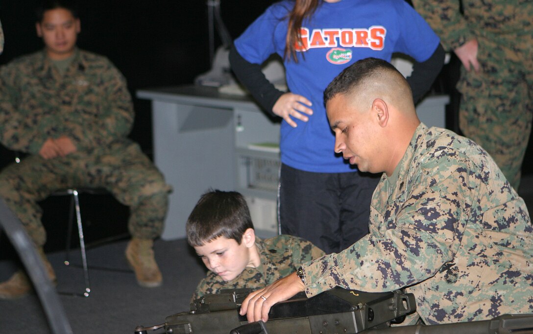 MARINE CORPS BASE CAMP LEJEUNE, N.C. (December 13, 2005) Brandon Rasnick has cystic fibrosis, and his dream was to be a Marine.  He wanted to wear the gear, be in the trenches and drive in a tank to make him an official Marine.  Sergeant Carlos F. Jaramillo, indoor simulated marksmanship training chief for Headquarters Battalion, 6th Marine Regiment, provided support to the Make-A-Wish project to help make a child's dream come true Dec. 13.