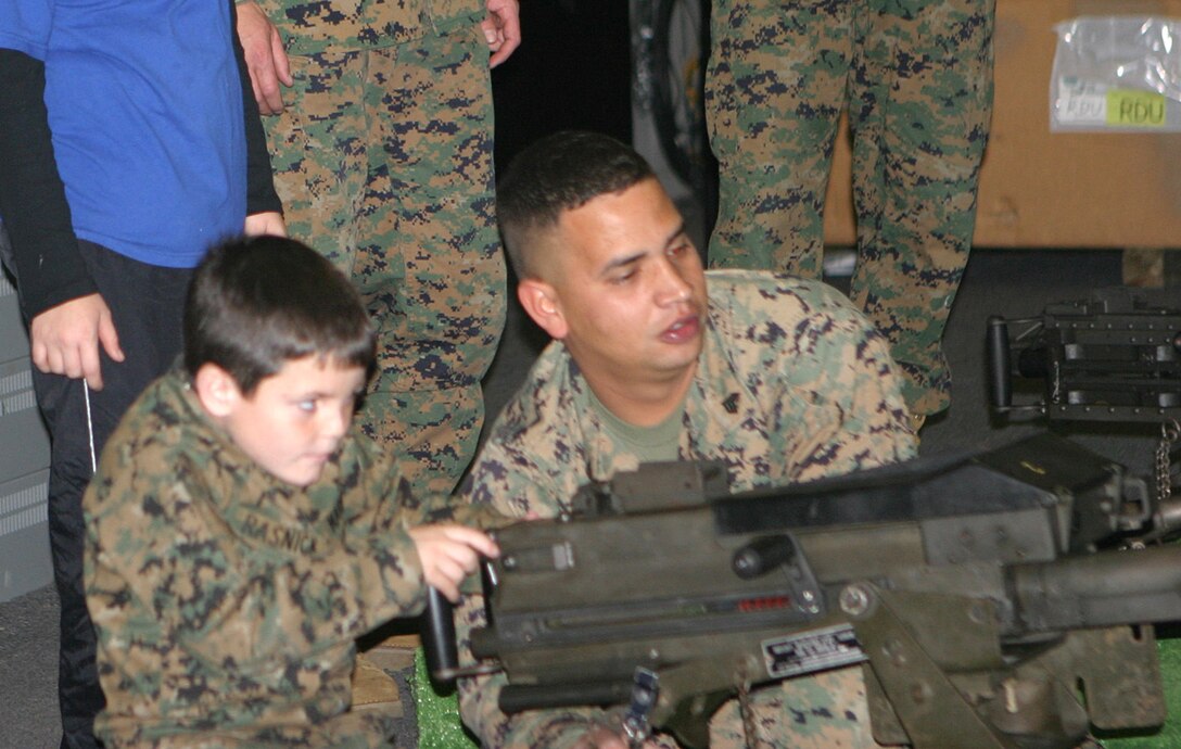 MARINE CORPS BASE CAMP LEJEUNE, N.C. (December 13, 2005) Brandon Rasnick has cystic fibrosis, and his dream was to be a Marine.  He wanted to wear the gear, be in the trenches and drive in a tank to make him an official Marine.  Sergeant Carlos F. Jaramillo, indoor simulated marksmanship training chief for Headquarters Battalion, 6th Marine Regiment, provided support to the Make-A-Wish project to help make a child's dream come true Dec. 13.