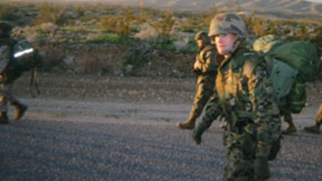 Lt. j.g. Tavis Long, base chaplain, volunteers his time during one of the conditioning hikes the battalion participated in during January. Long, who wasn't required to go on the hike, attended to motivate the troops.