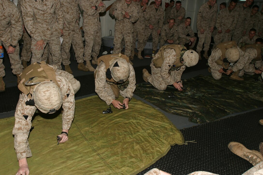 Marines with Charlie Company, Battalion Landing Team 1/1, 15th Marine Expeditionary Unit (Special Operations Capable) race to disassemble and reassemble assorted small arms weapons as part of their training while on board here.