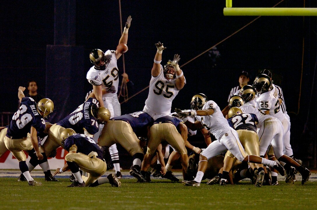 051222-N-6932-069::n::QUALCOMM STADIUM, SANDIEGO CALIF. (December 22, 2005) - Defensive End number 59, Jesse Nading of the Colorado State "Rams" blocks an attempted field goal by number 39, Joey Bullen the Place Kicker for the U.S. Naval Academy's "Midshipmen" in the inaugural Sandiego Credit Union Poinsettia Bowl. The Midshipmen defeated Colorado State with a score of 51-30, setting an academy record of a third consecutive year bowl game appearance.::n::U.S. Navy photo by Photographer's Mate 1st Class Richard J. Brunson. Cleared for public release by LCDR J. P. Bunnell, Executive Officer Combat Camera Group Pacific.