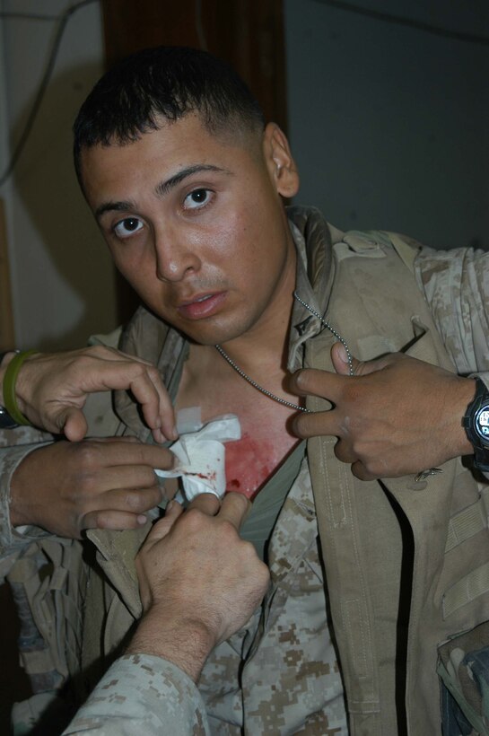 CAMP HURRICANE POINT, Ar Ramadi, Iraq (March 23, 2005) -Lance Cpl. Jaime M. Magallanes, a rifleman with 2nd Squad, 3rd Platoon, Company A, 1st Battalion, 5th Marine Regiment, was shot by an enemy sniper while on a patrol in the city here March 23. The 7.62 mm round nicked the top, right portion of the 22-year-old San Antonio, Texas, native's armored chest plate. The impact caused minor abrasions and bruising to his chest, nothing life threatening. The warrior refused to throw in the towel and continued to patrol with his fellow Marines for more than an hour and a half before receiving medical attention at the battalion aid station here.  Photo by Cpl. Tom Sloan