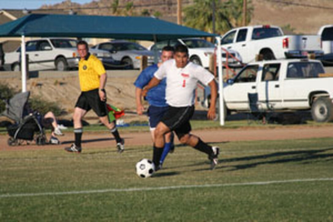 Luis G. Rodriguez of 1st Battalion, 7th Marine Regiment closes in on the goal, keeping one step ahead of a 3rd LAR defender during a June 23 game of the Commanding General?s Intramural Soccer League here at Felix Field.  1/7 went on to defeat their 3rd Light Armored Reconnaissance Battalion opponents sudden death shootout after the teams tied.