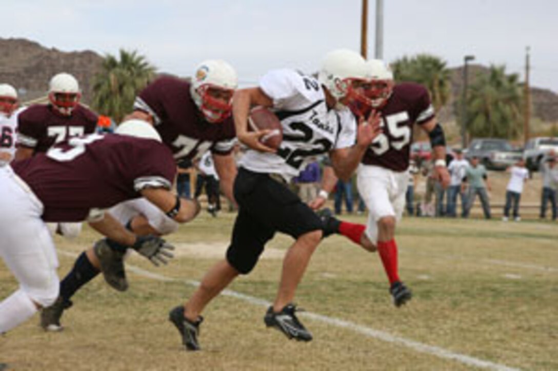 First Tank Battalion?s Daniel P. Wininger outruns Thomas Ulrich, Karl Taylor, Robert Osborne and John Ivans of 3rd Battalion, 4th Marine Regiment, Nov. 23 during the championship game of the Commanding General?s Tackle Football League.