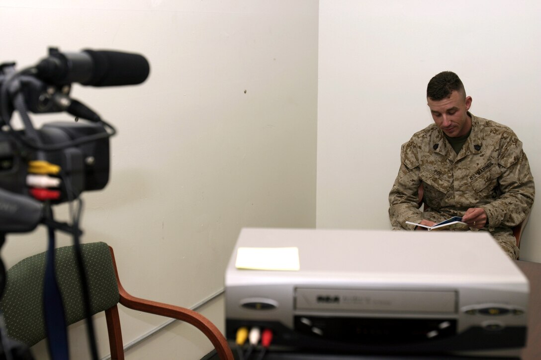 MARINE CORPS BASE CAMP LEJEUNE, N.C. - Gunnery Sgt. Joseph Poe, Weapons Platoon, Company B, 1st Battalion, 6th Marine Regiment platoon sergeant, reads a children's story book in front of the camera.  The Dunn, N.C. native and several of his fellow Marines participated in the United Through Reading program before deploying to Iraq so their kids could see and hear them even while "dad" was overseas.