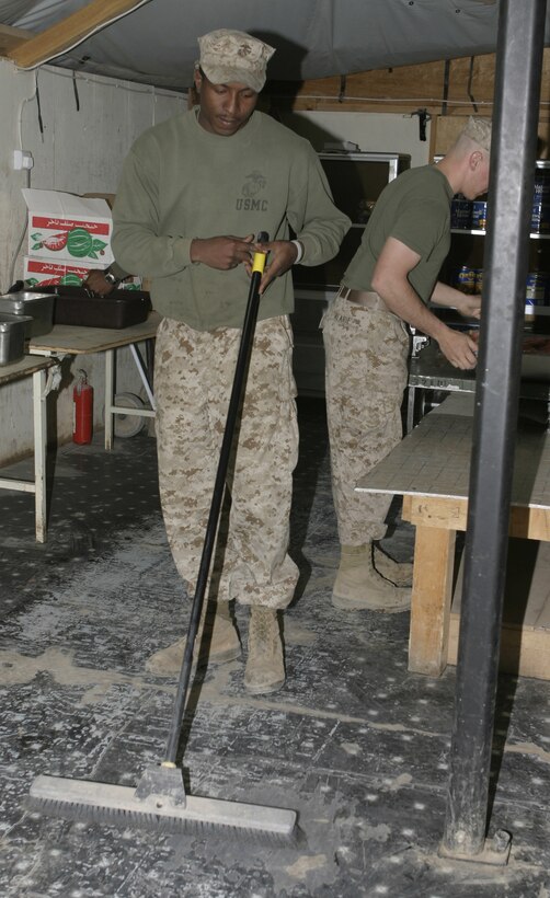CAMP BAHARIA, Iraq - Lance Cpl. Larry Jenkins, 1st Battalion, 6th Marine Regiment cook, sweeps out the mess tent after breakfast.  Jenkins and his fellow cooks work approximately 18 hours every day to ensure all the unit's Marines and sailors are well fed.