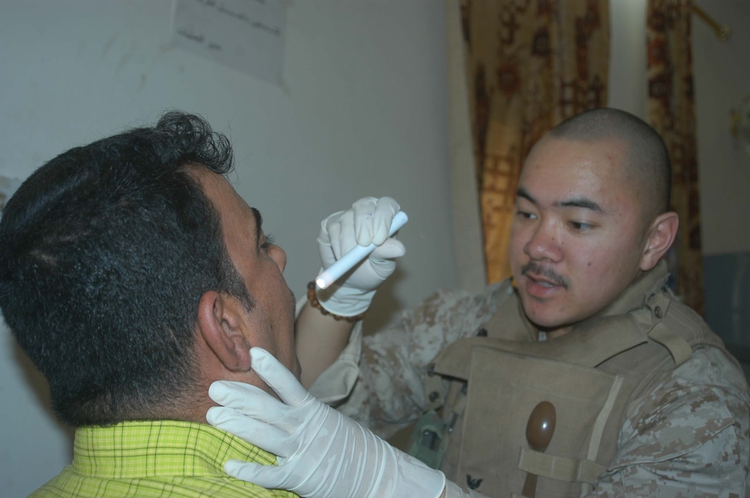AR RAMADI, Iraq (May 24, 2005) - Petty Officer 3rd Class Loui C. Villanueva, a field corpsman with 1st battalion, 5th Marines Regiment's battalion aid station, gives each man a physical examination at the infantry battalion's screening facility here at the Ramadi Police Headquarters. The man volunteered to be an Iraqi Police Officer and must undergo screening at 1st Battalion, 5th Marines' facility before being issued a sidearm, badge and paid a salary. The infantry battalion is conducting an operation to ensure qualified men fill the forces' ranks. The men take a written and oral exam, are given a physical examination, are entered into the infantry battalion's biometric automated toolset and are questioned as to why they want to serve. More than 500 Iraqis have volunteered. Villanueva, a 24-year-old from Vancouver, British Columbia, is permanent personnel at the facility. Photo by: Cpl. Tom Sloan