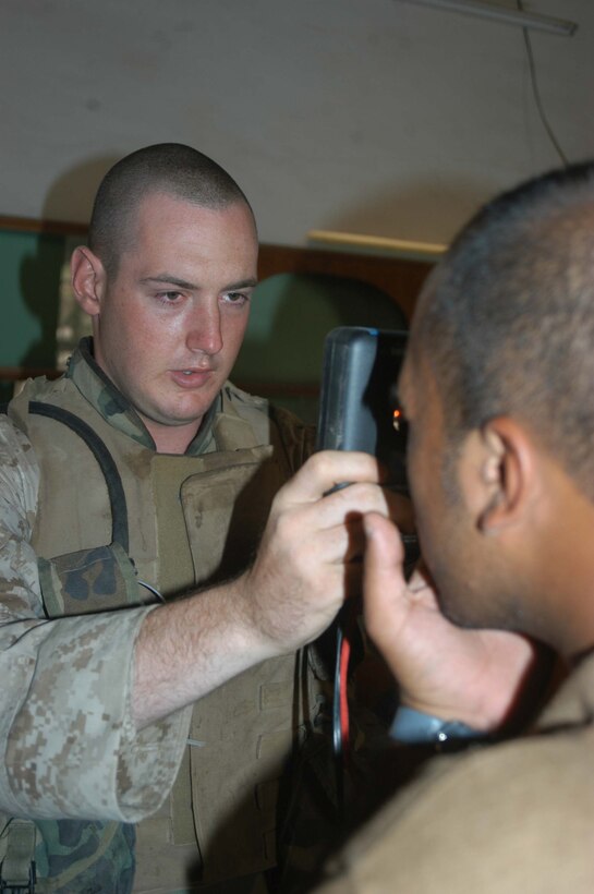 AR RAMADI, Iraq (May 24, 2005) - Private First Class Joshua W. Yarbrough, a rifleman with Company B, 1st Battalion, 5th Marine Regiment, enters an Iraqi man's iris into the biometric automated toolset at the infantry battalion's screening facility here at the Ramadi Police Headquarters. The man volunteered to be an Iraqi Police Officer and must undergo screening at 1st Battalion, 5th Marines' facility before being issued a sidearm, badge and paid a salary. The infantry battalion is conducting an operation to ensure qualified men fill the forces' ranks. The men take a written and oral exam, are given a physical examination, are entered into the infantry battalion's biometric automated toolset and are questioned as to why they want to serve. Yarbrough, a 19-year-old from Port Arthur, Texas, is permanent personnel at the facility. More than 500 Iraqis have volunteered. Photo by: Cpl. Tom Sloan