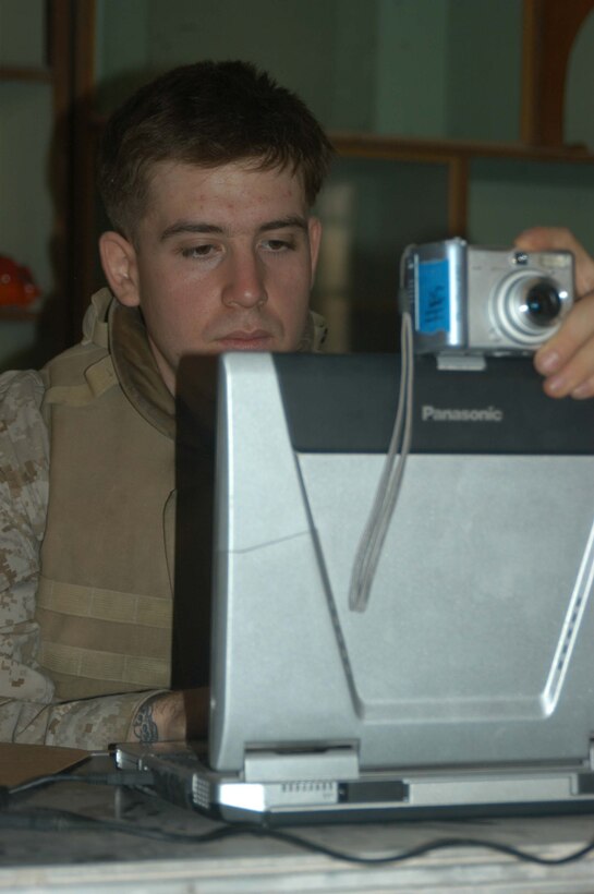 AR RAMADI, Iraq (May 24, 2005) - Lance Cpl. Adam R. Pulido, an intelligence analyst with Headquarters and Service Company, 1st Battalion, 5th Marine Regiment, takes an Iraqi man's photo and enters him into the biometric automated toolset at the infantry battalion's screening facility here at the Ramadi Police Headquarters. The man volunteered to be an Iraqi Police Officer and must undergo screening at 1st Battalion, 5th Marines' facility before being issued a sidearm, badge and paid a salary. The infantry battalion is conducting an operation to ensure qualified men fill the forces' ranks. The men take a written and oral exam, are given a physical examination, are entered into the infantry battalion's biometric automated toolset and are questioned as to why they want to serve. More than 500 Iraqis have volunteered. Pulido, a 21-year-old from Sonoma, Calif., is permanent personnel at the facility. Photo by: Cpl. Tom Sloan
