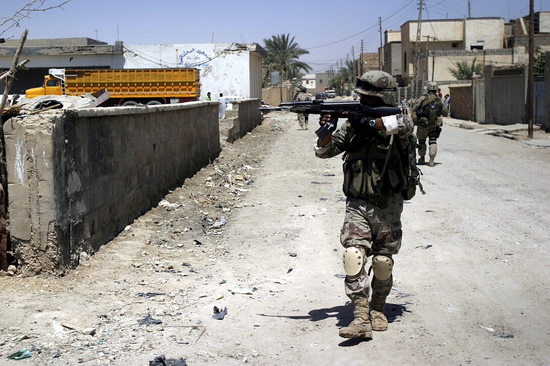 Hit, Al Anbar, Iraq (July 22, 2005)--Marines with Company "K", 3rd Battalion, 25th Marine Regiment and soldiers with Iraq Intervention Force patrol the streets. (Official USMC Photo by Corporal Ken Melton)