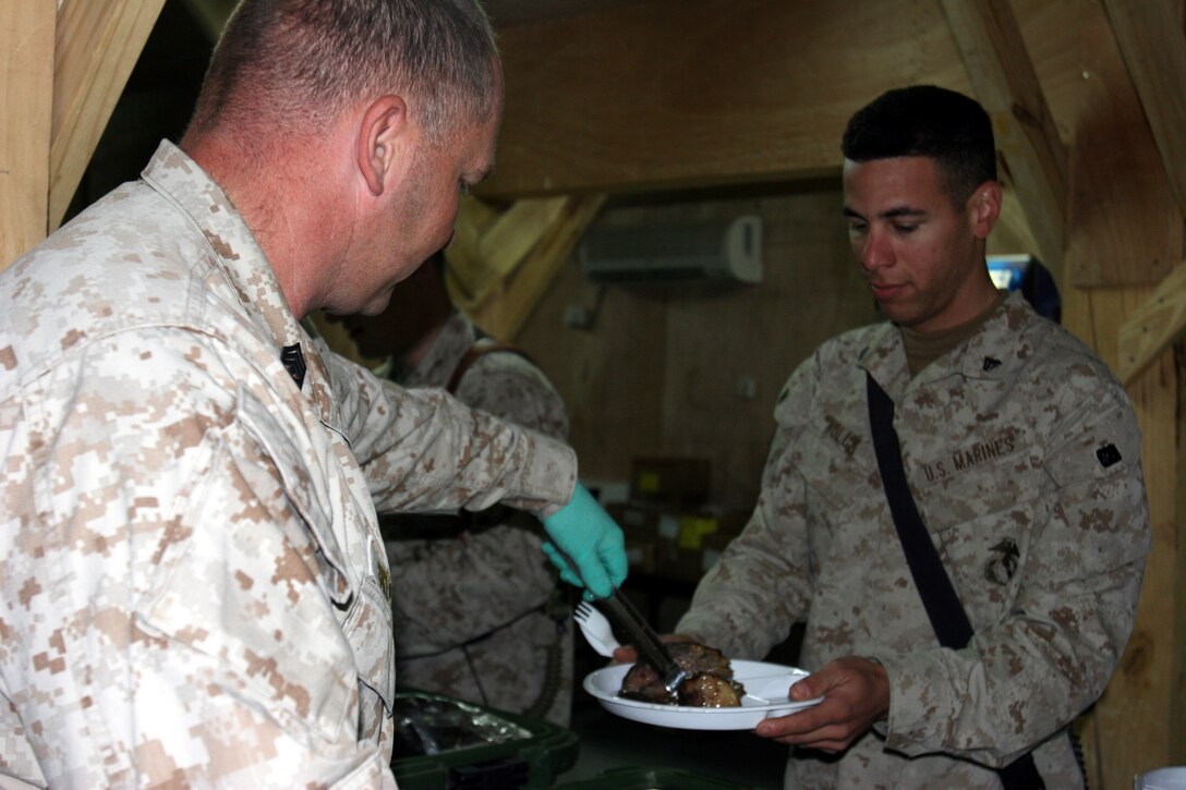 AR RAMADI, Iraq ? Company A?s 1st Sergeant serves Cpl. Kenneth Noya, a guard with 3rd Battalion, 7th Marine Regiment, during Thanksgiving here at the Hurricane Point chow hall Nov. 24.