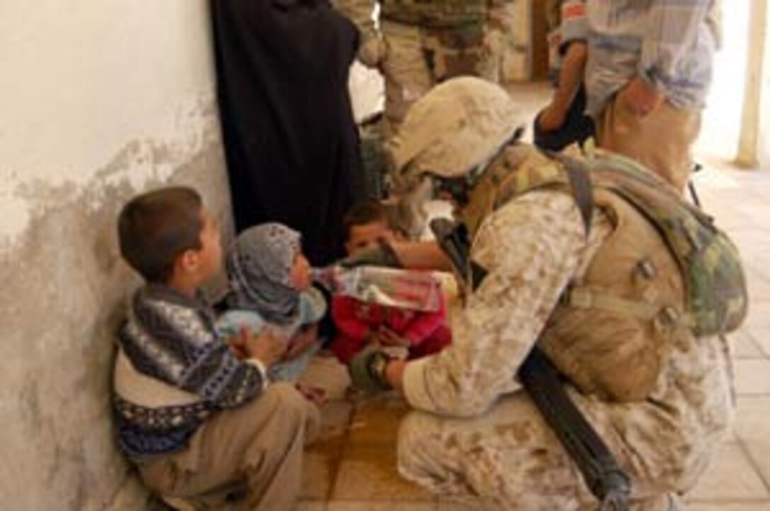 Cpl. Alberto Reategui, 22, an engineer with MEU Service Support Group 15 gives water to an Iraqi child during a Humanitarian Assistance mission at a school here.  The 15th Marine Expeditionary Unit (Special Operations Capable) is currently conducting security and stability operations here in the greater Baghdad area.