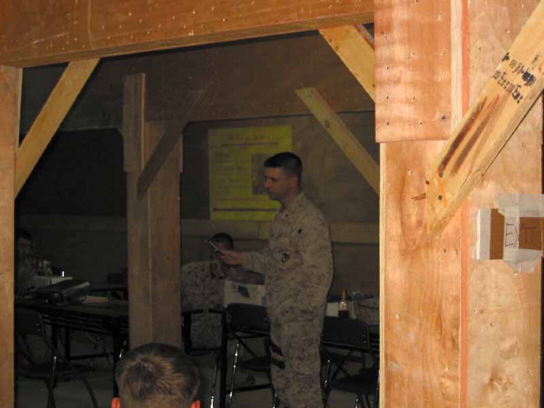 Lt. Cmdr. James Harris, 24th Marine Expeditionary Unit medical officer, briefs Marines on the Post Deployment Health Assessment required for all returning troops at Forward Operating Base Kalsu, Iraq.