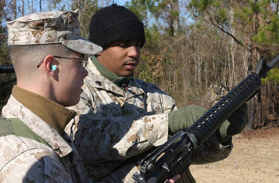 MARINE CORPS BASE CAMP LEJEUNE, N.C. (Jan. 25, 2004)-Corporal Kendrick R. Victoria, a 2d Marine Division Marksmanship Training Unit instructor and Bronx, N.Y. native assists a Marine with his sling during a recent coaches' course at Stone Bay here. Besides teaching at couches' courses, Victoria and the rest of MTU also teach Enhanced Marksmanship Programs and foreign weapons courses to deploying Marines.
