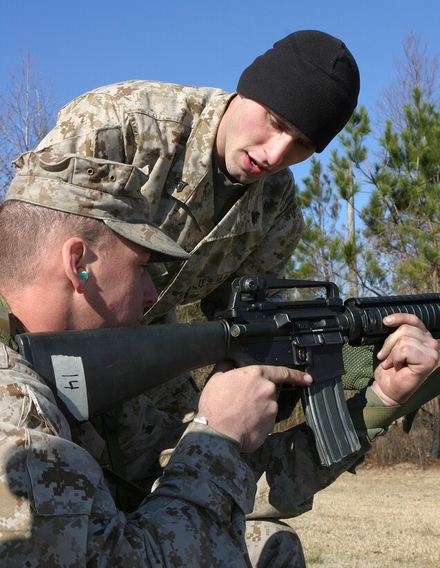 MARINE CORPS BASE CAMP LEJEUNE, N.C. (Jan. 25, 2004) - Corporal Josh D. Alford, a 2d Marine Division Marksmanship Unit instructor helps a Marine as he shoots his M-16 during a recent coaches' course here. Alford, a Knoxville, Tenn. native has spent the last year teaching Marines about marksmanship with MTU.