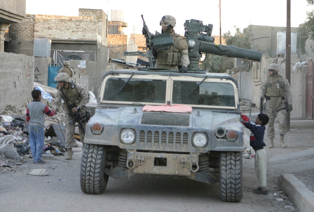 FALLUJAH, Iraq - Pfc. Jarrell W. Poole, vehicle gunner with 1st Combined Anti-Armor Team Platoon, Weapons Company, 1st Battalion, 6th Marine Regiment, looks out on the city as his unit patrols the back alleyways of Fallujah.  The Pollock, La. native's unit typically patrols the city streets several times a day, maintaining a strong military presence here and searching for insurgents and illegal arms.