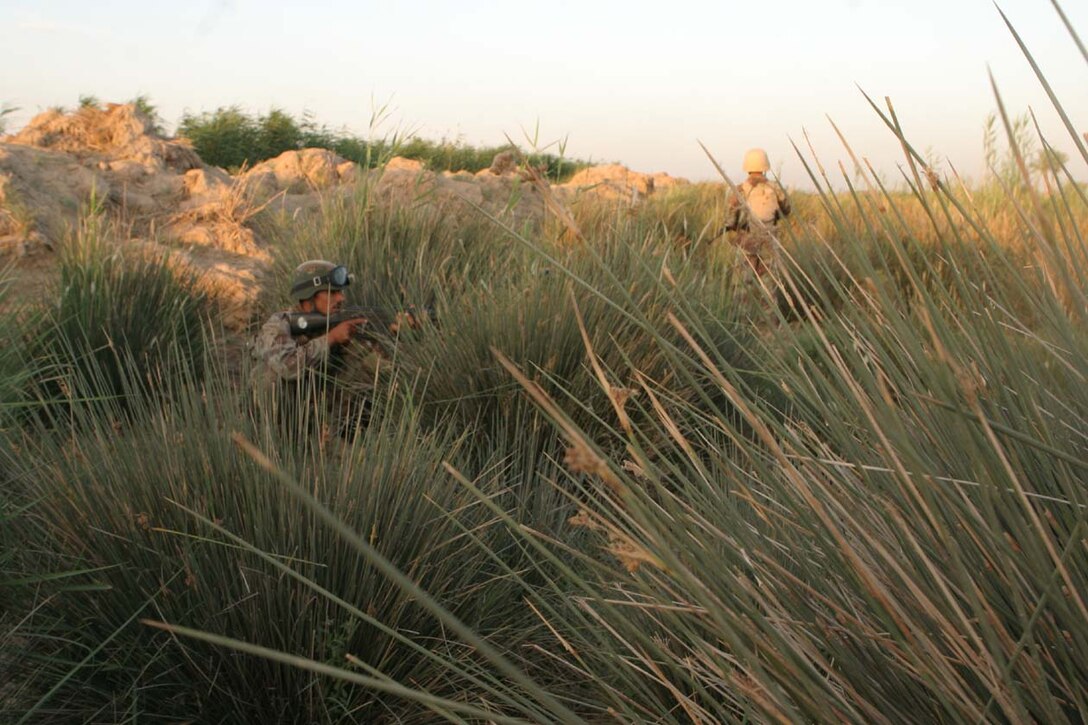 AL KARMAH, IRAQ -- Iraqi Security Force members sit in the shrubery waiting for oncoming traffic to stop and check for illegal weapons systems or any type of improvised explosive devices.  The ISF have watched and learned from the Marines over the past four months on how to effectively check vehicles and personnel.  Official U.S. Marine Corps photo by Lance Cpl. Athanasios L. Genos