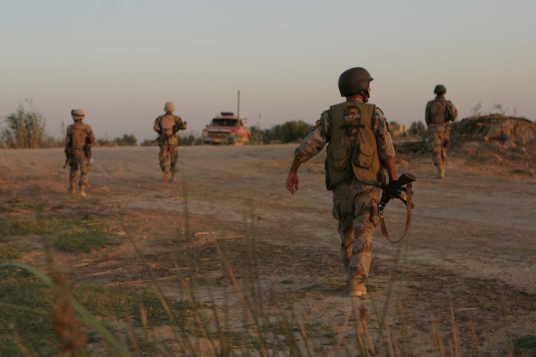 AL KARMAH, IRAQ -- Iraqi Security Force Members move from a hidden position up to an oncoming vehicle to stop it and check it for any illegal weapons or propaganda.  The ISF are gradually taking over more responsibilities as they learn and watch the Marines of 3rd Battalion, 8th Marine Regiment.  Official U.S. Marine Corps photo by Lance Cpl. Athanasios L. Genos