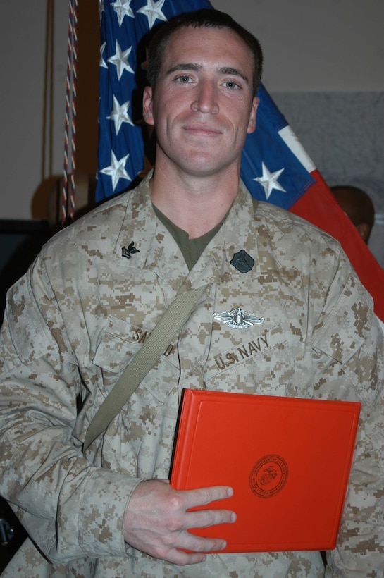 CAMP HURRICANE POINT Ar Ramadi, Iraq (July 24, 2005) - Petty Officer 2nd Class Benjamyn Savard, a hospitalman and the senior line corpsman for Company W, 1st Battalion, 5th Marine Regiment, recently earned his Fleet Marine Force pin and was awarded it during a ceremony here July 24. The 29-year-old from San Diego used every chance he had to study the FMF books so he could pass the test. Over the course of 45 days, when he wasn't on missions in the Al Anbar capital with his Marine comrades, he devoted his time to studying. Earning the FMF pin symbolizes his knowledge of Navy and Marine Corps history, customs and courtesies and Marine Corps and amphibious operations. Savard enlisted in the Navy after graduating from Cosby High School in 1994. He was 17-years-old. This is his second deployment to Iraq supporting Operation Iraqi Freedom in as many years. Photo by: Cpl. Tom Sloan