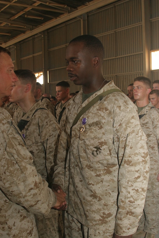 CAMP AL QA'IM, Iraq (July 25, 2005)- Lance Cpl. Calvin Mitchum, 20, a rifleman with Company K, 3rd Battalion, 2nd Marine Regiment, Regimental Combat Team-2 receives a Purple Heart from Gen. Michael W. Hagee, commandant of the Marine Corps during a visit here July 25. (Official U.S. Marine Corps photo by Lance Cpl. Lucian Friel (RELEASED)