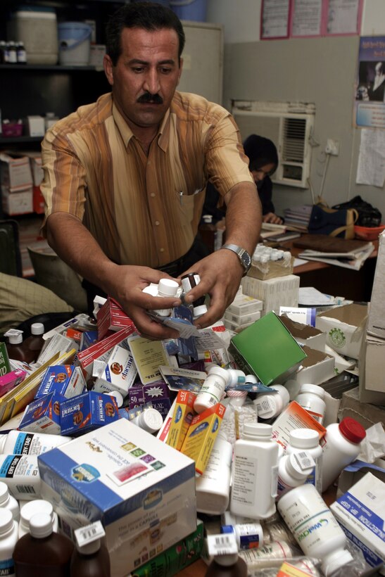 FALLUJAH, Iraq - An Iraqi physician sorts through bottles and boxes of medication inside his clinic here Aug. 25 during Operation Medical Mentoring.  U.S. Marines and Iraqi Security Forces visited several local clinics to hand out supplies such as children's cough suppressants, blood pressure regulating medications, and as many as 100,000 Tylenol tablets.