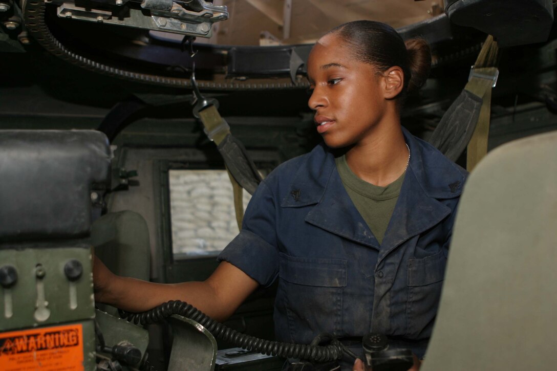CAMP BLUE DIAMOND, RAMADI, Iraq - Corporal Jessica L. Curtis, the communications chief for Truck Company, Headquarters Battalion, 2nd Marine Division checks the operation of a radio. Curtis has logged more than 6000 miles on the roads here and is responsible for ensuring that the Marines driving in the convoys can talk to each other to coordinate their movements. Curtis also maintains the systems in each vehicle that block and prevent the detonation of roadside Improvised Explosive Devices. Official U.S. Marine Corps photo by Sgt. Ryan S. Scranton
