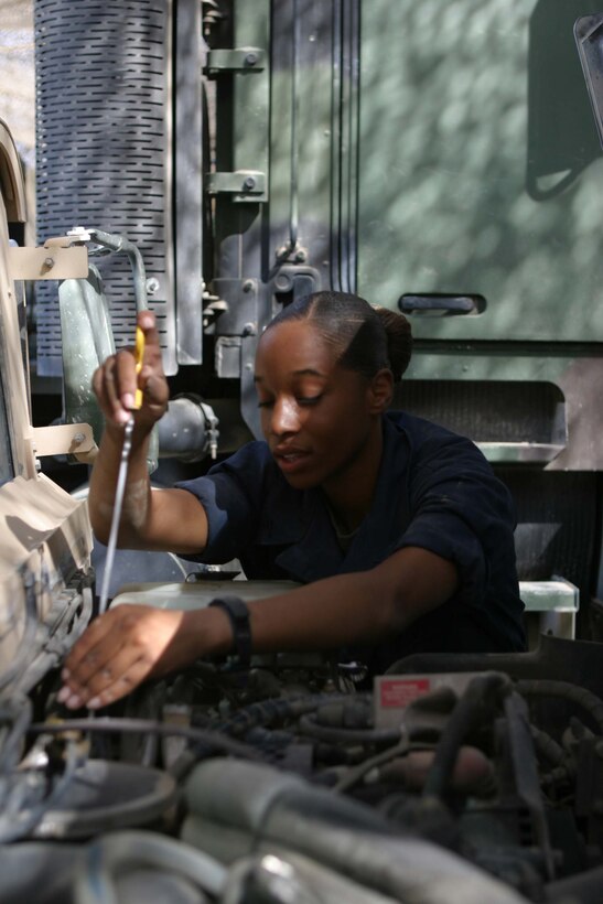 CAMP BLUE DIAMOND, RAMADI, Iraq - Corporal Jessica L. Curtis, the communications chief for Truck Company, Headquarters Battalion, 2nd Marine Division checks the oil of her humvee. Curtis has logged more than 6000 miles on the roads here and is responsible for ensuring that the Marines driving in the convoys can talk to each other to coordinate their movements. Curtis also maintains the systems in each vehicle that block and prevent the detonation of roadside Improvised Explosive Devices. Official U.S. Marine Corps photo by Sgt. Ryan S. Scranton