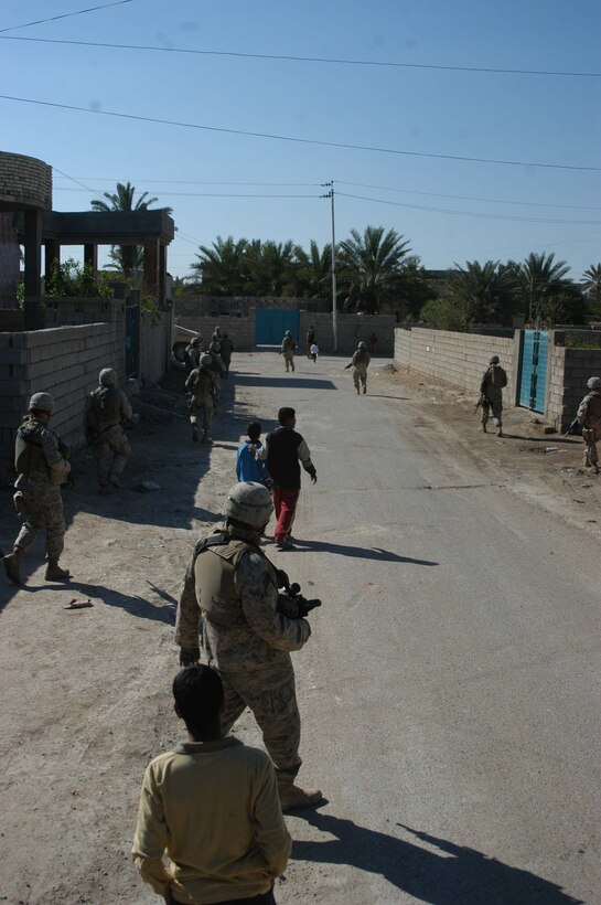 AR RAMADI, Iraq (March 25, 2005) - Iraqis accompany Marines with 1st Platoon, Company B, 1st Battalion, 5th Marines, as they patrol their neighborhood. Leathernecks with 1st Platoon, Company B, 1st Battalion, 5th Marines, searched several houses in the western part of the city here March 25 for a man they suspect is a member of the jihad group Jaysh Mohamed, which is connected with producing improvised explosive devises and has been linked to several IED attacks. They also searched for illegal weapons, weapons caches and checked identification cards of the men in each house they searched. Photo by Cpl. Tom Sloan